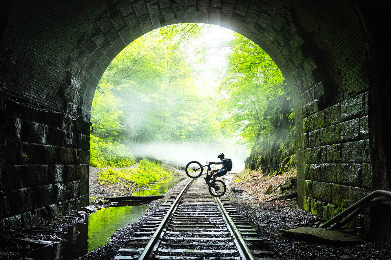 Mountain biker riding through a stone tunnel