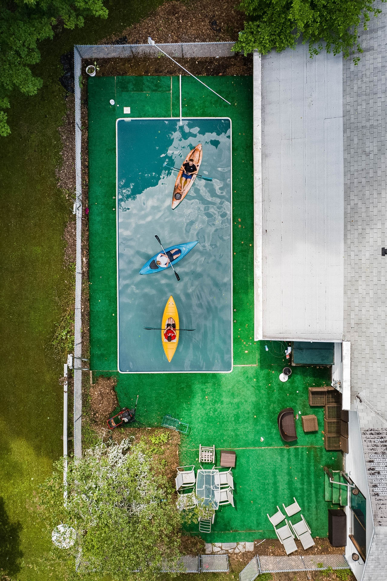 Three kayaks from above in a backyard pool
